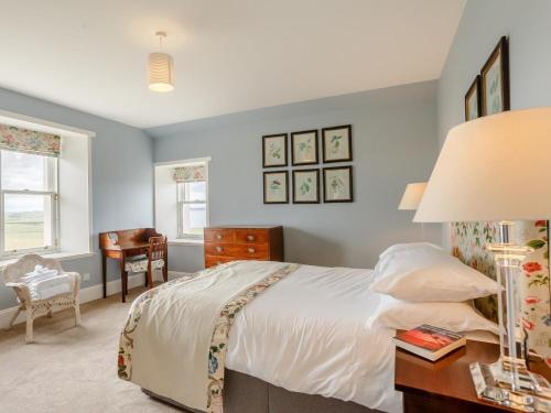a bedroom with a bed and a desk with a lamp at 3 Bed in Thurso oc-ca337 in Mey