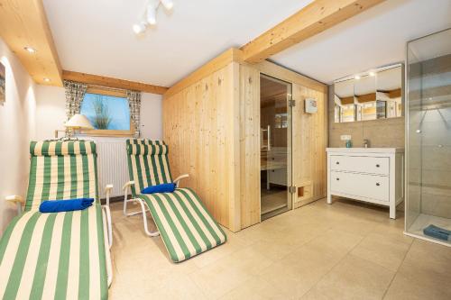 a room with two green and white chairs and a desk at Alpen Lodge Chiemgau in Schleching