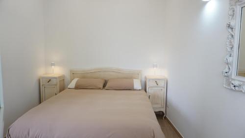 a bedroom with a white bed with two night stands at La Casetta in Monteforte Irpino