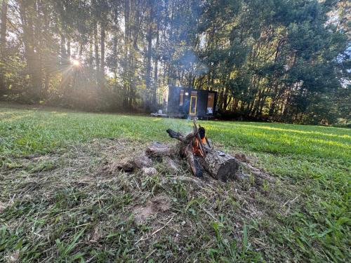 a pile of wood in the middle of a field at The Secret Place by Tiny Away in Palmvale