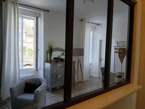a mirror in a room with a chair and a window at Le 46 Clos Vert in Erquy