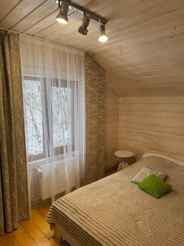 a bedroom with a bed and a window at Карпатська Модрина in Kosiv