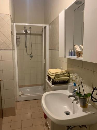 a white bathroom with a sink and a shower at La Canonica Di San Michele in Monteriggioni
