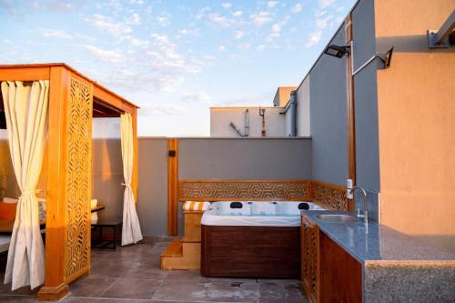 a bathroom with a bath tub on a balcony at VELORA Serviced Rooftop Studio With Private Jacuzzi in Sodic New cairo in New cairo