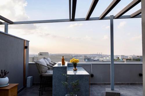a balcony with a table and a view of the city at VELORA Serviced Rooftop Studio With Private Jacuzzi in Sodic New cairo in New cairo