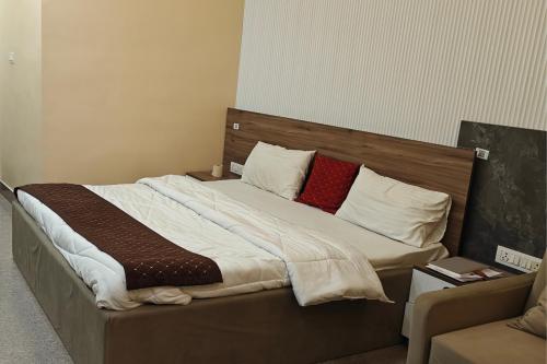 a large bed with two red pillows on it at Amantran Farm Retreat in Varanasi