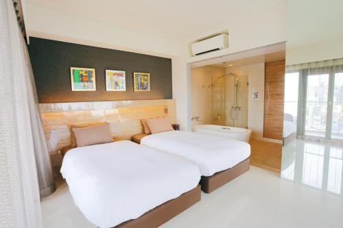 a bedroom with two beds and a bath room at HOTEL Viviana in Naha