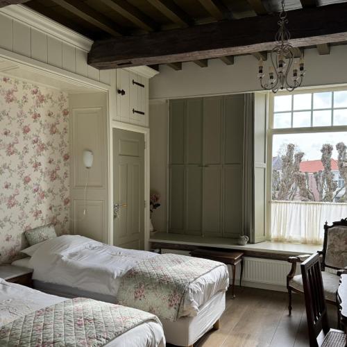 a bedroom with two beds and a window at Inn de Vijf Sinnen in Geertruidenberg