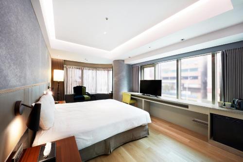 a hotel room with a bed and a television at CHECK inn Taipei Nanjing in Taipei