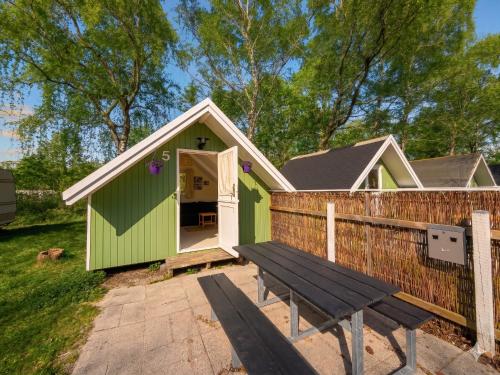 a green shed with a bench in front of it at Frederiksværk Camping & Hostel in Frederiksværk