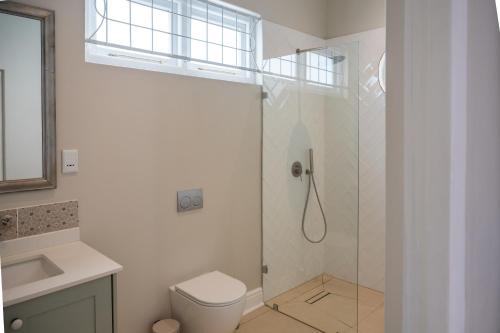 a bathroom with a shower with a toilet and a sink at Hoof House in Riebeek-Kasteel