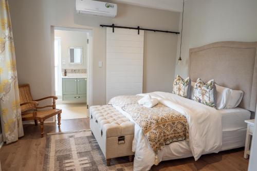 a bedroom with a bed and a bench in it at Hoof House in Riebeek-Kasteel