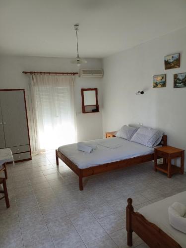 ein Schlafzimmer mit einem großen Bett und einem Fenster in der Unterkunft Lissia Hotel in Skala Eresou