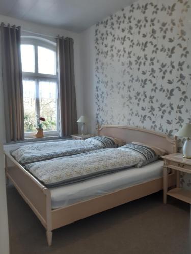 a bedroom with a bed with a floral wallpaper at Meeresleuchten 1 in Emden