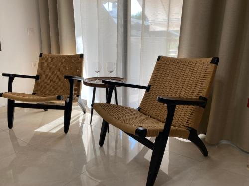 two chairs and a table with wine glasses on it at Irini Apartment in Hanioti