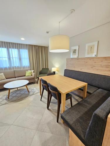 a living room with a table and a couch at Bergresort Gerlitzen in Treffen
