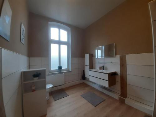 a bathroom with a toilet and a sink and a window at Meeresleuchten 1 in Emden