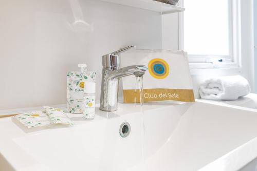 a bathroom sink with a faucet and a box on it at Club del Sole Spina Family Collection in Lido di Spina