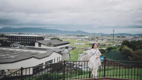 a woman in a white dress standing on a balcony at Fairfield by Marriott Nara Tenri Yamanobenomichi in Tenri