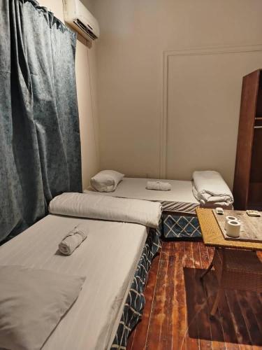 a room with two beds and a table in it at Colour Holidays in Cairo
