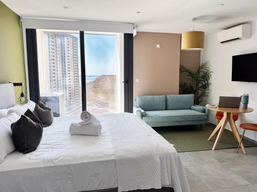 a bedroom with a bed and a couch and a window at E1 Suites & Spa aparthotel style - Gym & Spa in Gibraltar