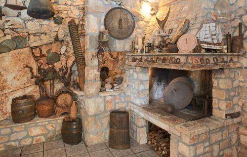 a stone room with a stone fireplace with a stove at Villa Jagodna in Hvar