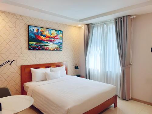 a bedroom with a bed and a painting on the wall at THE STAR HOTEL - PHU MY HUNG, HO CHI MINH - Korean Buffet Breakfast in Ho Chi Minh City