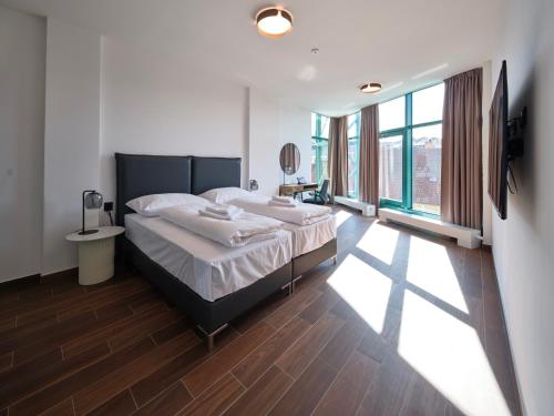 a bedroom with a large bed and a large window at Rezidence Třebíč in Třebíč