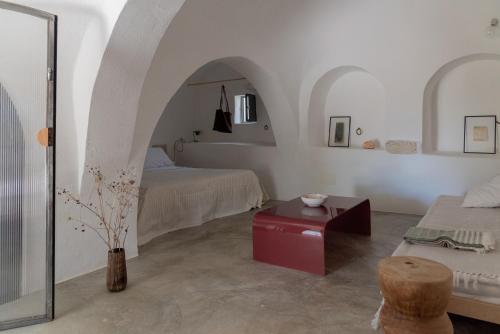 a white room with a bed and a table at Masseria Noja in Noci