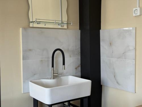 a bathroom with a white sink and a mirror at Shpola Central Hotel in Shpola