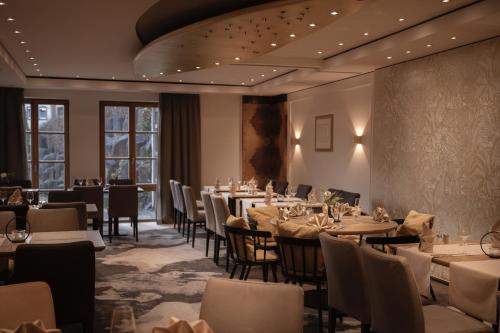 a dining room with tables and chairs and windows at Hotel Eisbach in Ransbach-Baumbach