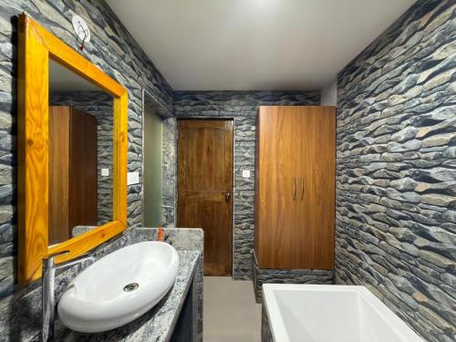 a bathroom with a sink and a stone wall at Marron Sea View Resort in Patnem