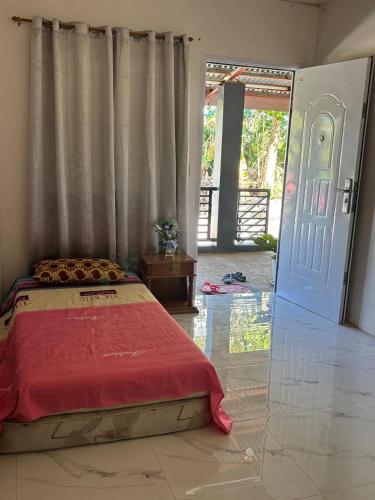 a bedroom with a bed with a red blanket and a door at Private Villa in Masbate