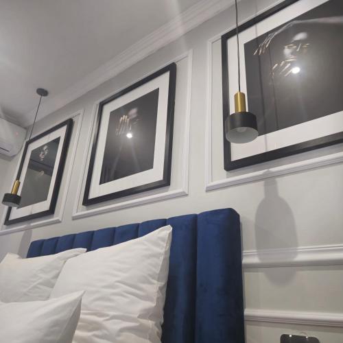 a bedroom with a blue couch and framed pictures at Maison Akiba in Pretoria