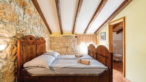 a bedroom with a wooden bed in a stone wall at Villa Sabrane by Villas Guide in Bale