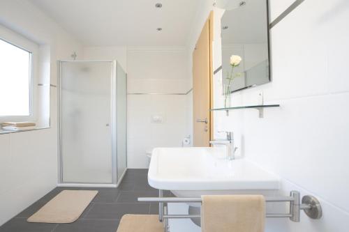 a white bathroom with a sink and a mirror at Haus am Apfelhain in Gangelt