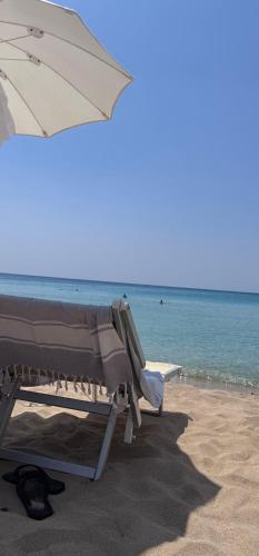 a beach chair with an umbrella on the beach at Dimora Anna Maria in Salve