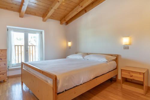 a bedroom with a large bed and a window at Leonardo al Maso Fovo in Andalo