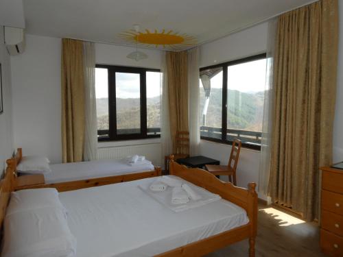 a bedroom with two beds and a window at Guest House Daskalov in Chervena Lokva