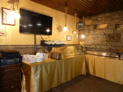a kitchen with a table with a television on it at Guest House Daskalov in Chervena Lokva