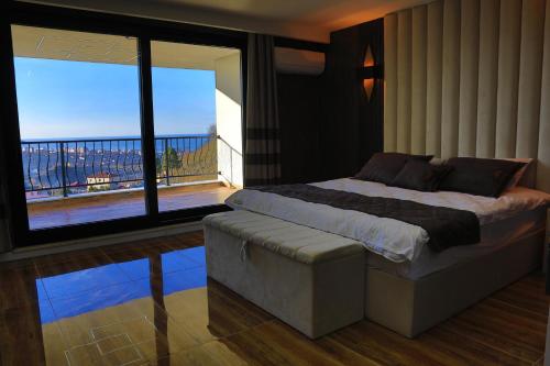 a bedroom with a large bed and a balcony at Gelevera Park - Otel Spa Restaurant in Espiye