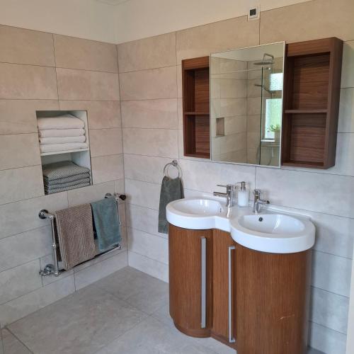 a bathroom with a sink and a mirror and towels at Cherrymount Cottage in Newcastle