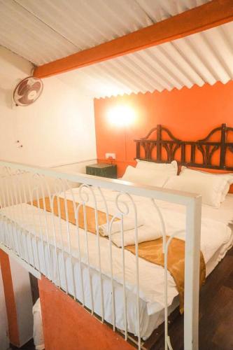 a bedroom with two bunk beds with an orange wall at The Coastal Nest in Daman