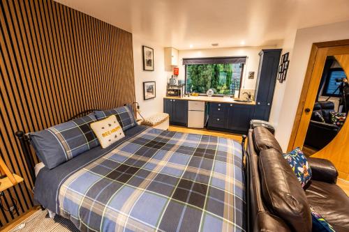 a bedroom with a bed and a couch in it at The Hive at Bee Happy Breaks Scotland in Perth