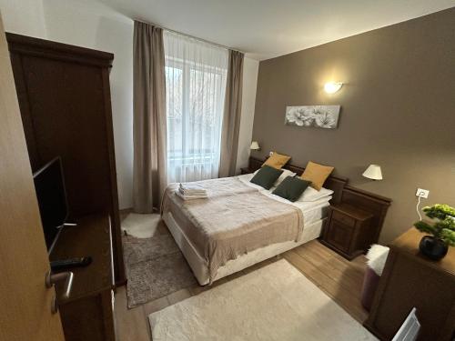 a small bedroom with a bed and a window at Edelweiss Mountain Apartment - Stream Resort Spa & Pool, Pamporovo in Pamporovo