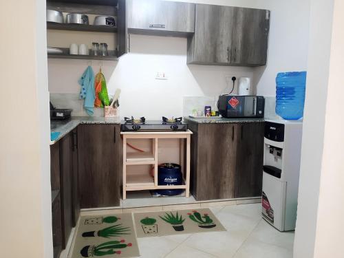 a small kitchen with wooden cabinets and a sink at Nolan's Comforts Kitengela in Kitengela 