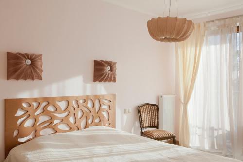 a bedroom with a bed and a chair and a window at Apartament Polonia in Ełk