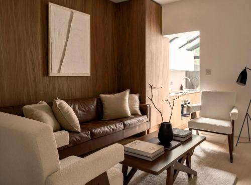 a living room with a couch and a table at Elegant 3BR Garden Flat - Steps from Central Oxford in Oxford