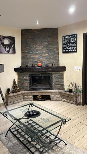 a living room with a fireplace and a glass table at chez Kay in Vétraz-Monthoux
