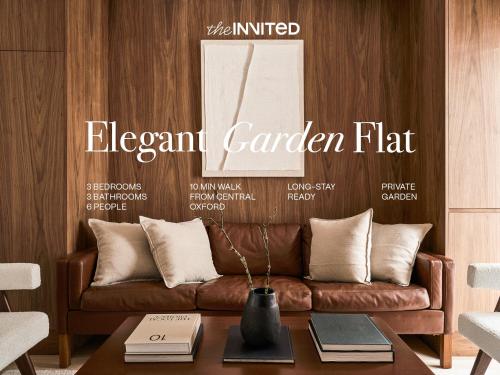a living room with a brown leather couch at Elegant 3BR Garden Flat - Steps from Central Oxford in Oxford